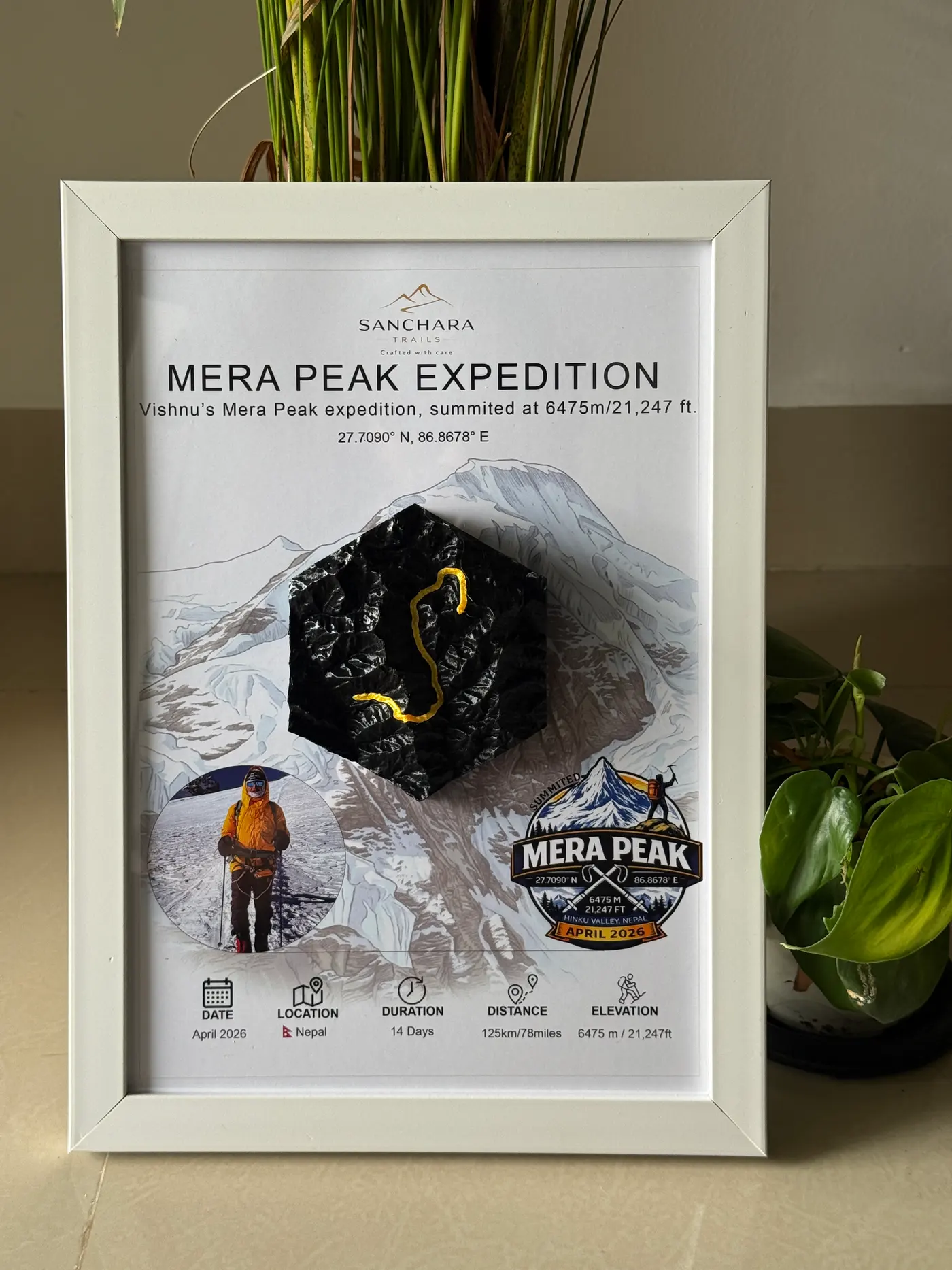 A framed Mera Peak Expedition trail map displayed beside a houseplant