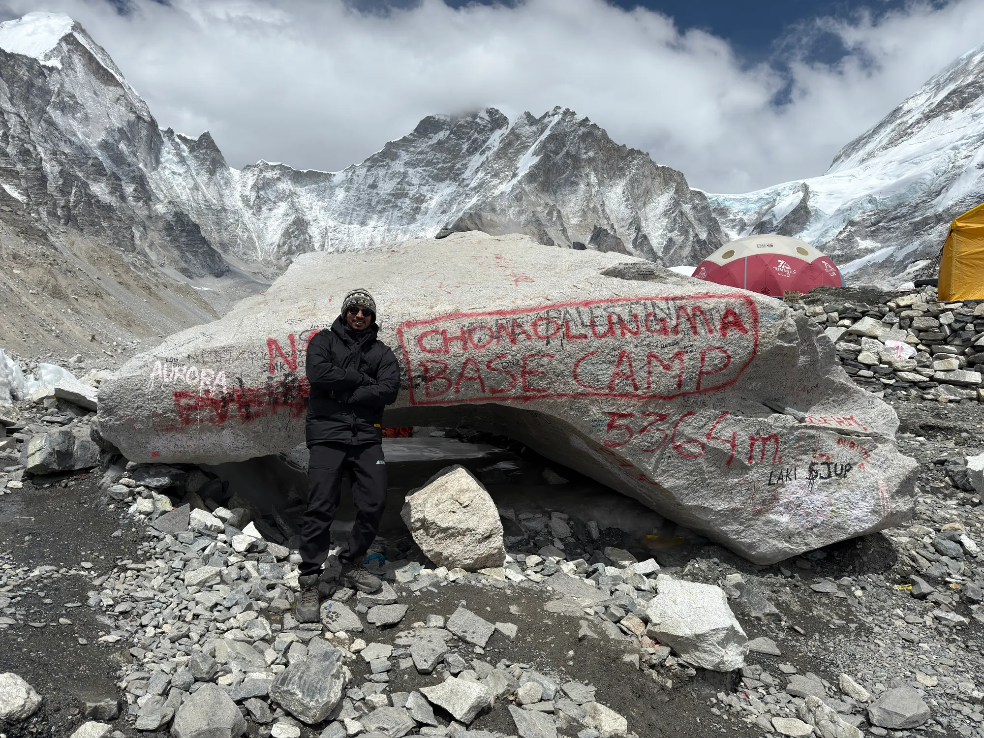 Aditya standing at the painted Everest Base Camp rock