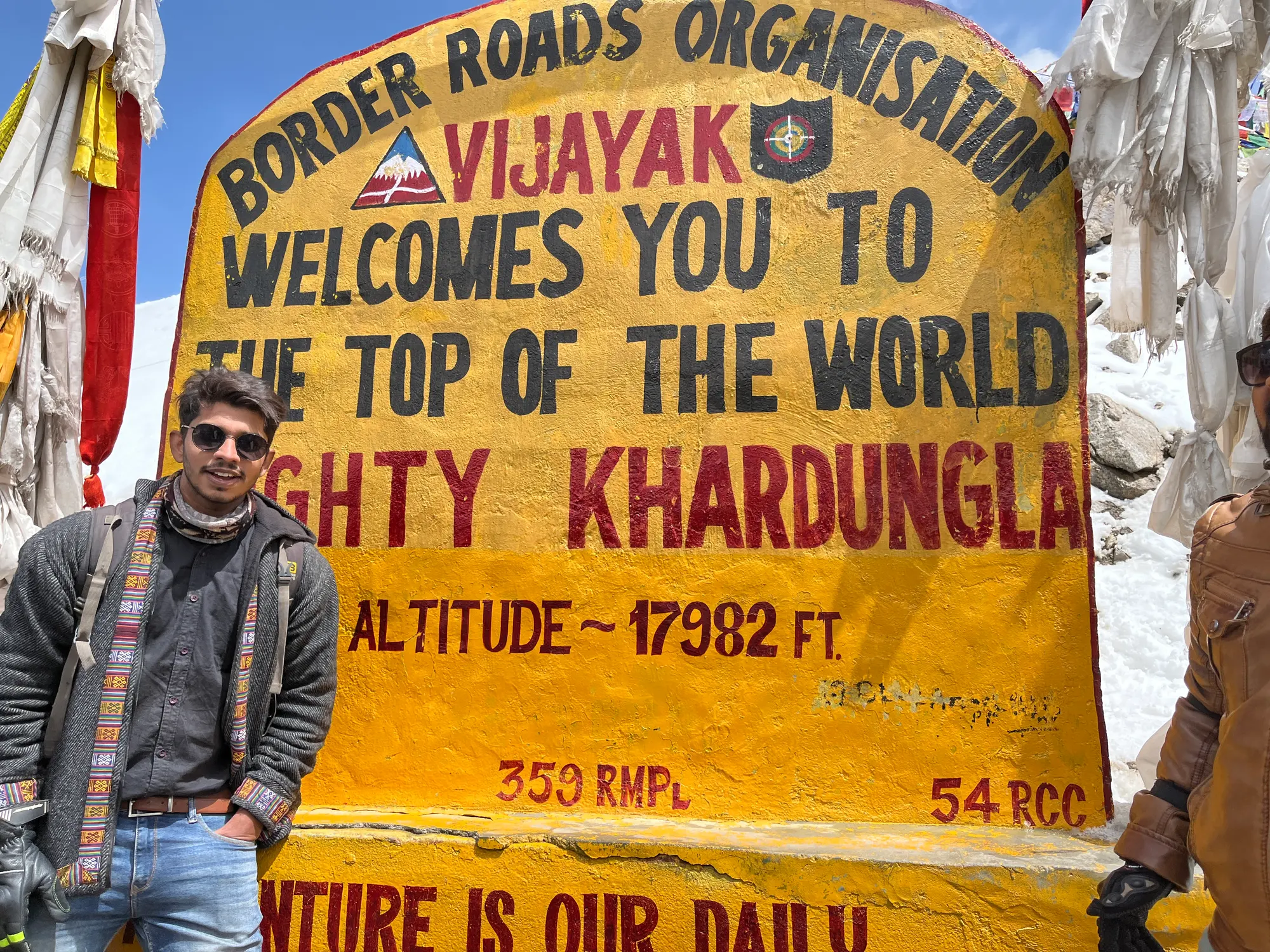 Aditya beside the Khardung La altitude sign at 17,982 ft